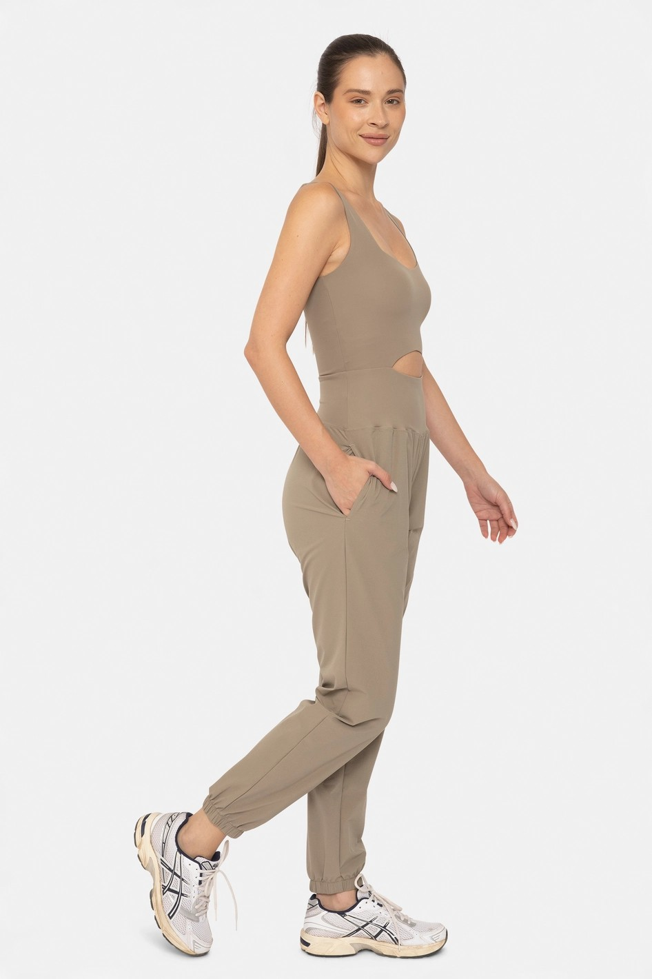 Woman wearing a beige jumpsuit on a white background