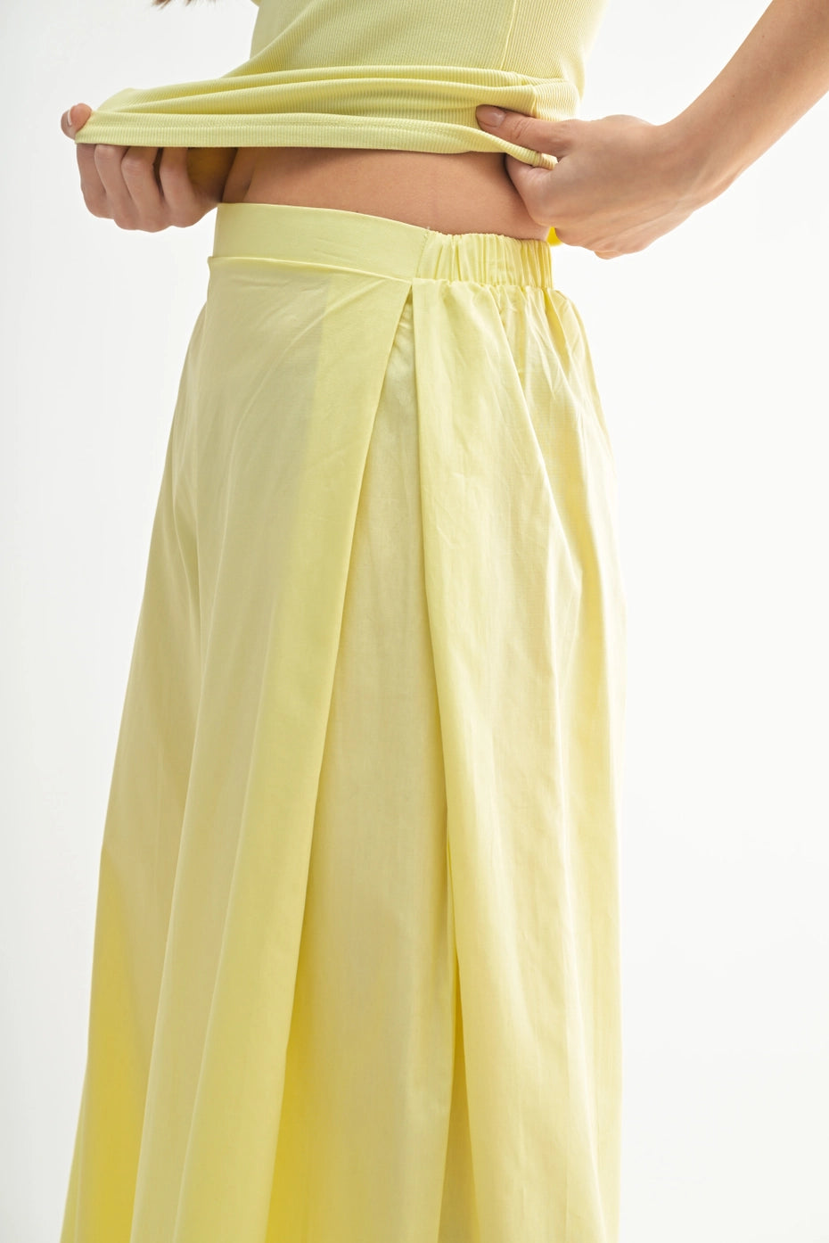 Yellow outfit with wide leg pants and top on a plain background