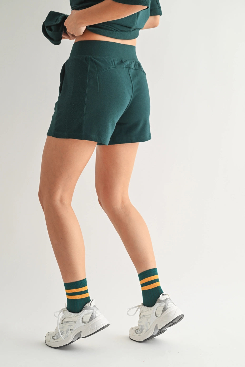 Person wearing green shorts and socks with a white background