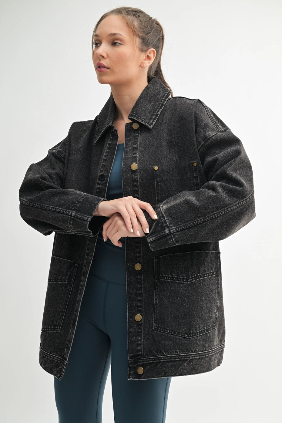 Woman wearing a black denim jacket on a white background